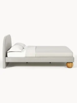 Cama tapizada con patas esfericas de madera Rena
