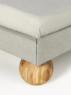 Cama tapizada con patas esfericas de madera Rena