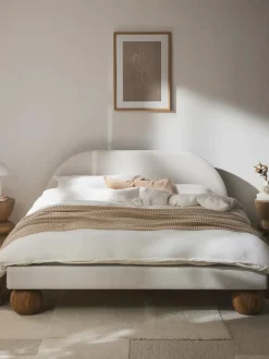 Cama tapizada con patas esféricas de madera Rena