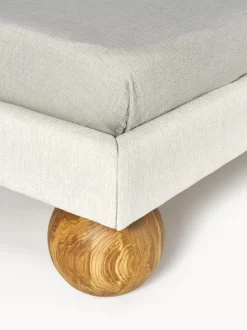 Cama tapizada con patas esféricas de madera Rena