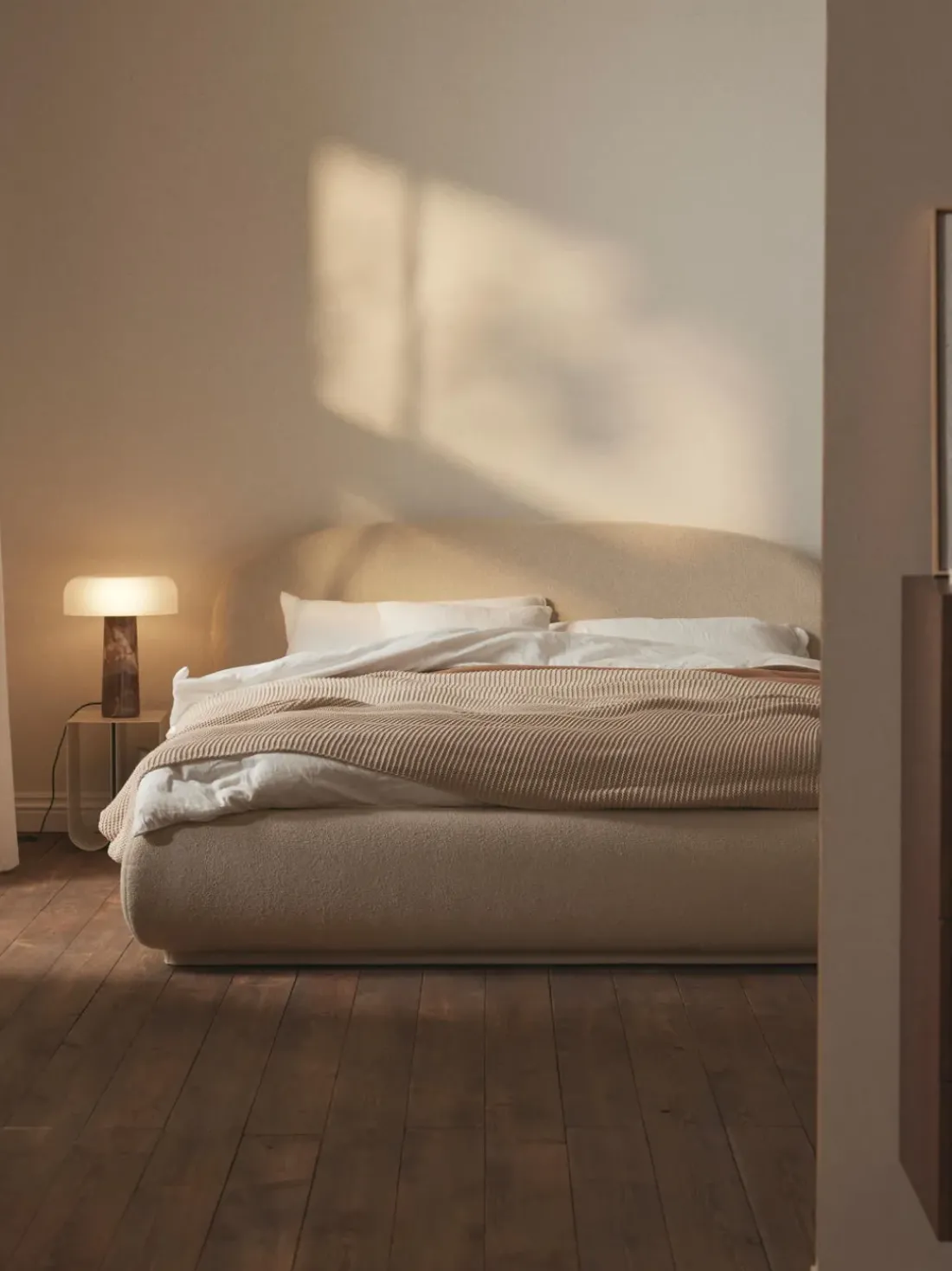 Cama tapizada redondeada en tejido bouclé Alba